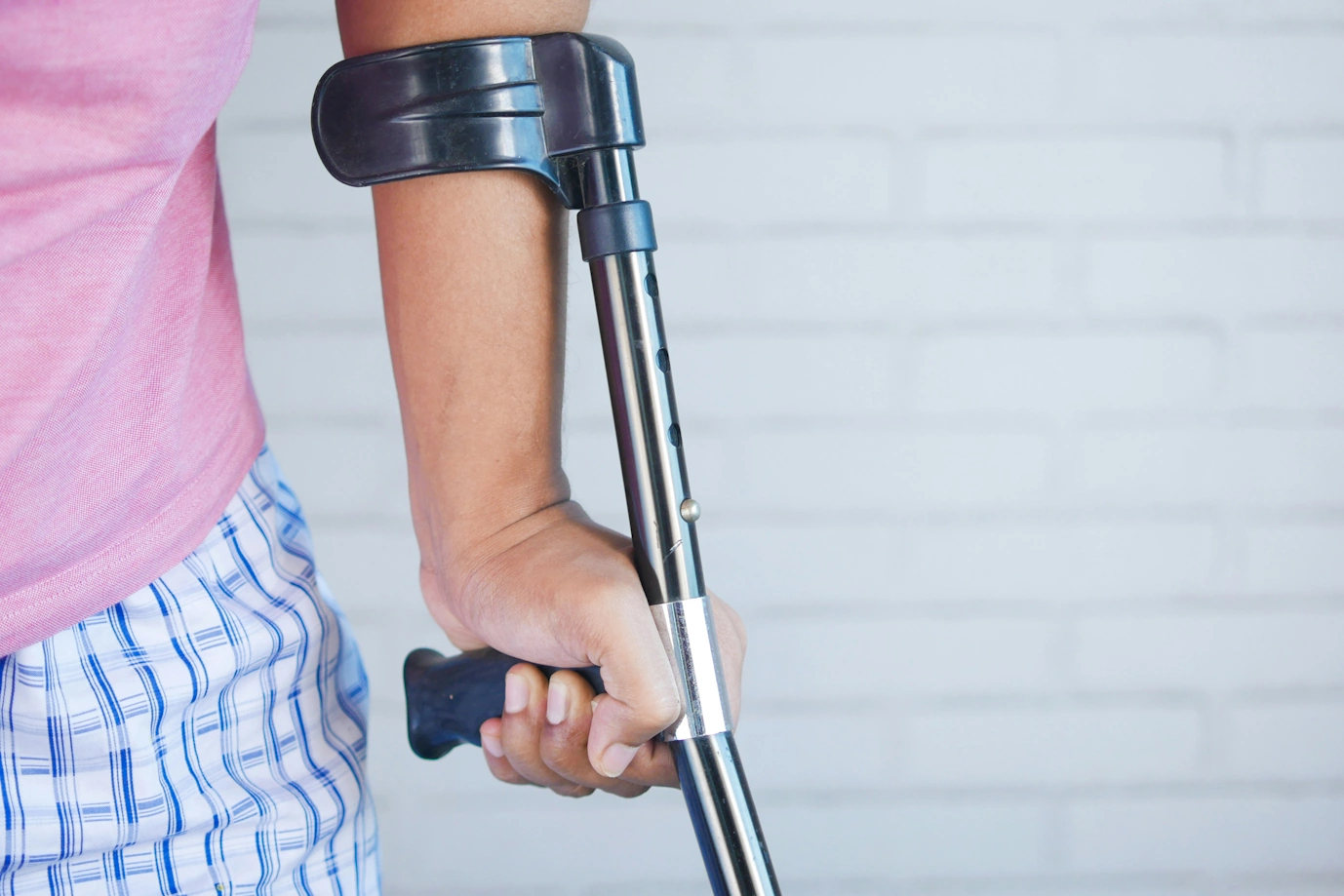 A man who is using a crutch to support his weight.